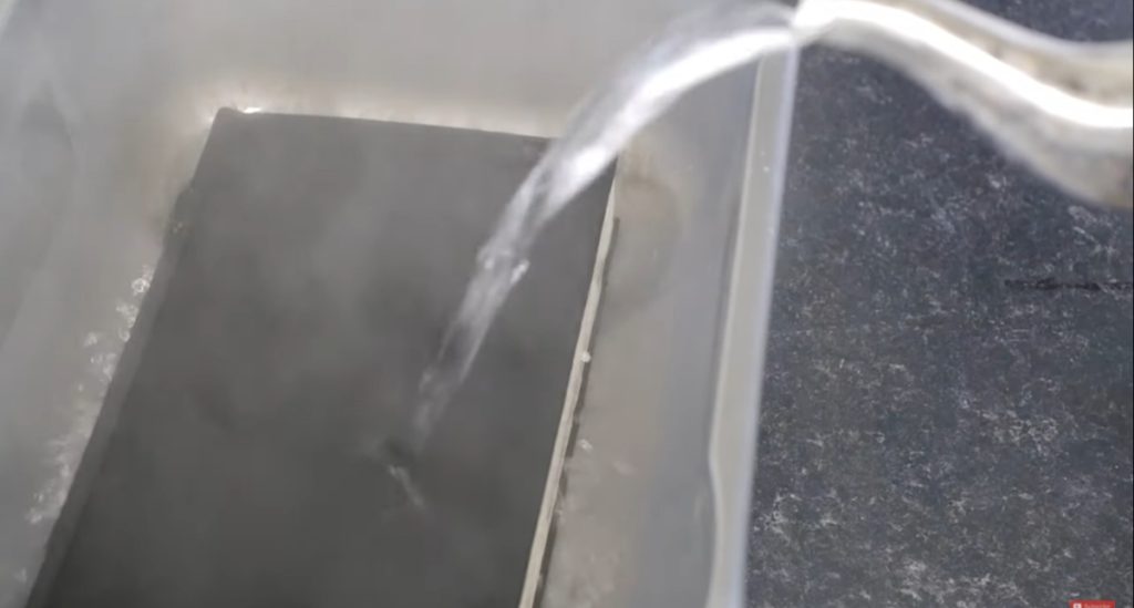 Pouring boiling water onto a hardcover book to pasteurize it before growing mushrooms