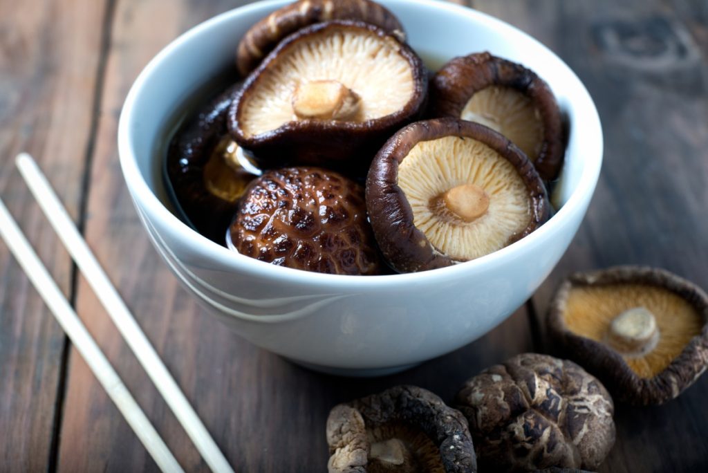 Dried shiitake mushrooms rehydrating in a bowl of water