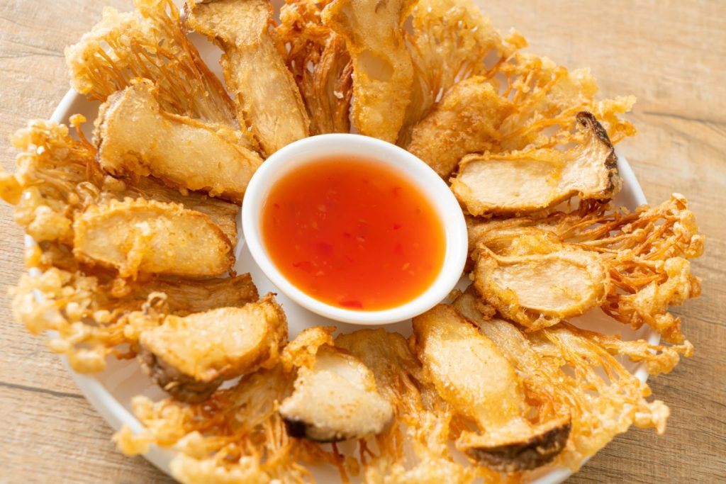 Asian cuisine. Deep fried king oyster and enoki mushrooms with a dipping sauce