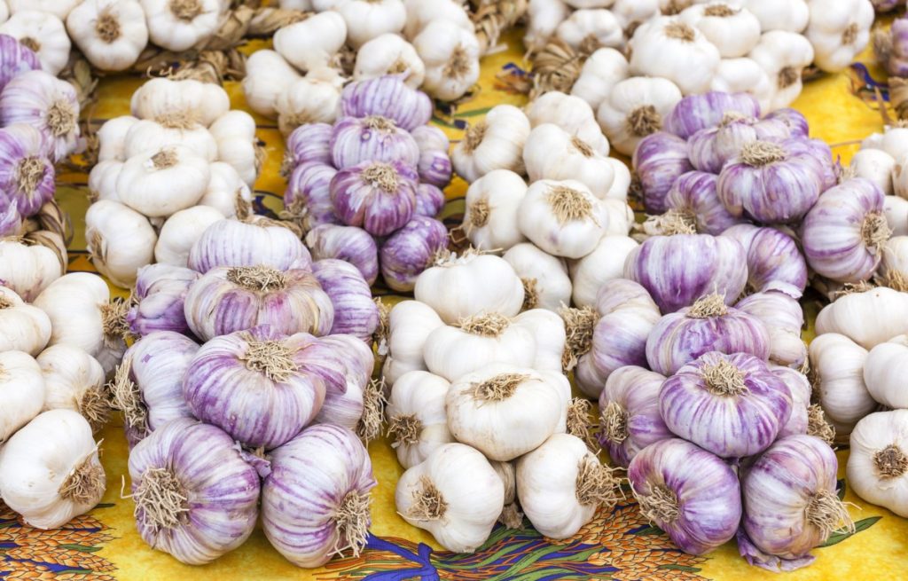 Different varieties of garlic for sale at a farmers market.