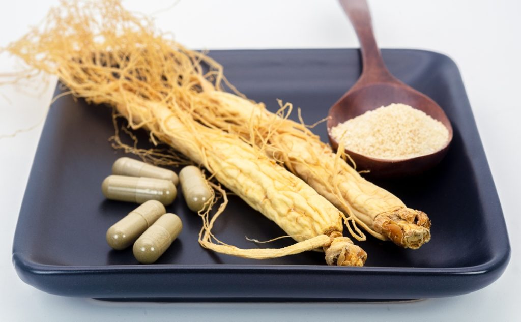 Dried ginseng root with ginseng powder and capsules.